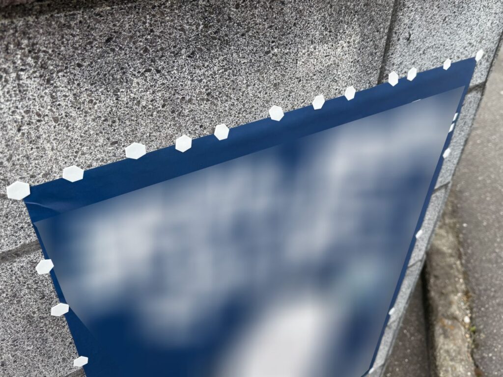 大量のテープを使って掲示しているポスター